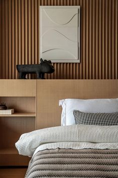 a bed sitting in a bedroom next to a wooden shelf with a cow figurine on top of it