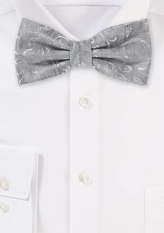 This Festive Silver Proper Paisley Bowtie will make everyone in your wedding party seem absolutely beautiful. The paisley design is woven into the fabric, which provides the tie with a smooth surface and allows it to shimmer when exposed to light. Combines splendidly with a black suit or tuxedo and a white shirt for an elegant look. Elegant Paisley Print Tie As A Gift, Elegant Paisley Print Ties As Gift, Elegant Silver Suit And Tie Accessories For Party, Fitted Paisley Print Suit And Tie Accessories For Wedding, Silver Party Tie, Elegant Formal Ties With Paisley Print, Wedding Ties With Paisley Print, Elegant Wedding Ties With Paisley Print, Elegant Silver Bow Tie For Formal Occasions