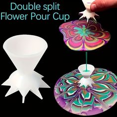 a hand is holding a flower cup and an object that looks like it has been made out of paper