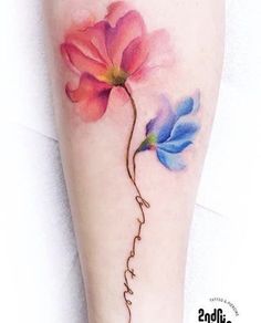 a woman's leg with flowers painted on it and the word love written in cursive writing