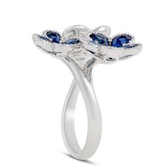 Sapphire petals grow out from a diamond center to form the shape of flowers. Milgrain detailed edges add even more sparkle to this unique design. Elegant Diamond Flower Ring, Elegant Butterfly Ring With Prong Setting For Anniversary, Luxury Flower-shaped Rings With Center Stone, Elegant Flower Shaped Ring With Prong Setting, Elegant Flower Rings With Prong Setting, Fine Jewelry Flower Ring With Accent Stones, Elegant Flower Ring With Prong Setting, Fine Jewelry Floral Rings With Accent Stones, Elegant Butterfly Ring With Prong Setting For Wedding