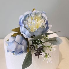 a white cake with blue and yellow flowers on top