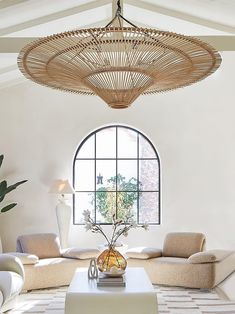 a living room filled with furniture and a large window in the middle of the room