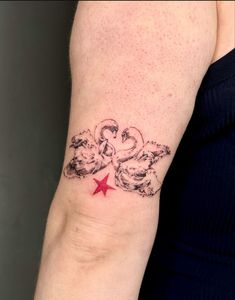 a woman's arm with a red star and two doves tattoo on it