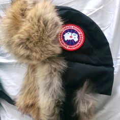 a furry hat with a canada goose fur on it's side and a canadian goose fur cap on top