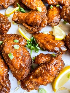 fried chicken wings with lemon wedges and parsley on the side, ready to be eaten