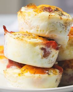 some food is stacked on top of each other in a white plate with yellow and red toppings