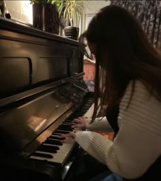 a woman is playing the piano in her living room