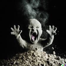 a creepy creature with its mouth wide open and hands in the air, surrounded by rocks