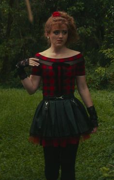 a woman in a red and black dress holding an umbrella