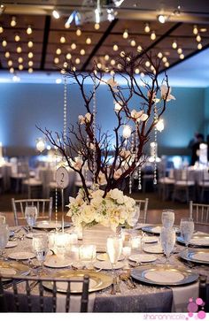 the centerpieces are decorated with branches, flowers and candles for an elegant touch