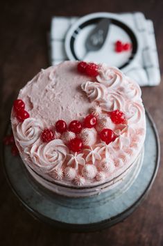 a cake with white frosting and red berries on top