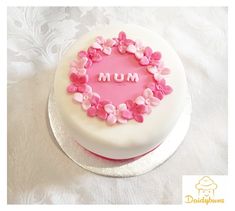 a white cake with pink flowers and the word mum on it