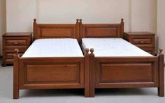 two beds with wooden headboards and night stands