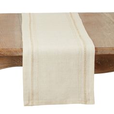 a wooden table with a white linen runner on it