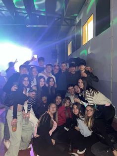 a group of young people posing for a photo in front of a neon colored wall