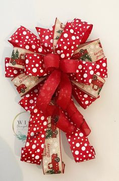 a red and white polka dot bow with christmas decorations on the front, attached to a wall