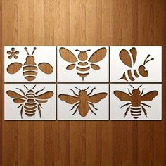 four bees cut out from paper on a wooden surface