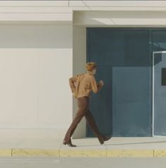 a woman walking down the street in front of a building