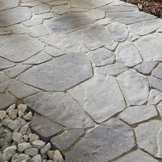 a stone walkway with rocks and gravel in the foreground