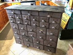 an old metal filing cabinet in a kitchen with lots of drawers on the top and bottom