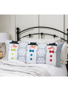 a bed with snowmen on it and two pillows