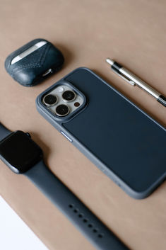 an iphone case sitting on top of a table next to a pen and cell phone