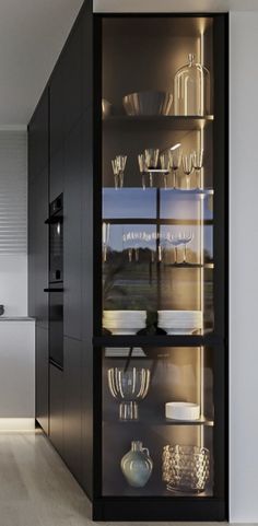 an open cabinet in the middle of a kitchen with white chairs and counter tops on each side