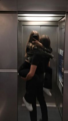 two people hugging each other in an elevator