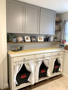 a kitchen with gray cabinets and white curtains