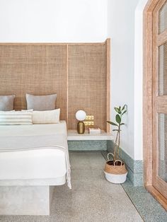 a white bed sitting next to a wooden headboard