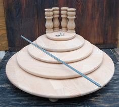 a set of four wooden candlesticks sitting on top of each other