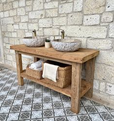 two sinks are sitting next to each other in front of a brick wall and tiled floor