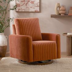 an orange chair sitting on top of a white rug next to a vase filled with flowers