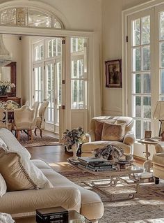 a living room filled with lots of furniture next to large windows and french doors on the side