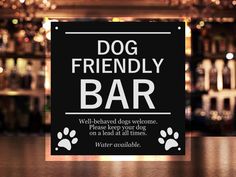 a dog friendly bar sign sitting on top of a table