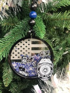 an ornament hanging from a christmas tree decorated with american flag and police badges