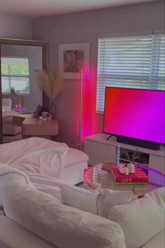 a living room filled with furniture and a flat screen tv sitting on top of a table