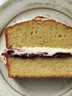 a piece of bread with cream and blueberries on it is sitting on a plate