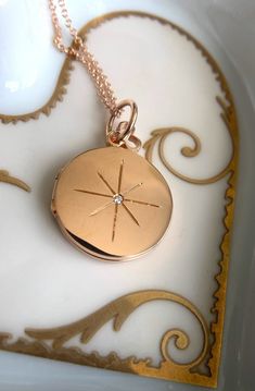 Inspired by the orienting star that has long been used by those seeking guidance in the night sky. Our 'North Star' locket, along with its bespoke interior, serves as a beacon of hope and inspiration. This locket features a radiant star motif, accented with diamonds. ** *Multitasker: Florentine North Star on one side, Shiny North Star on the other side. Details 18K Yellow Gold Locket18mm in Diameter2 White Diamonds, TCW 0.02ctStandard Chain Included: 16" 14K 1.3mm Cable Chain with Lobster Clasp Star Locket, Gold Pendant Set, Star Motif, Ring Bracelet Chain, Round Locket, Beacon Of Hope, Locket Charms, The Night Sky, Moon Charm