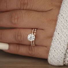 a woman's hand with two engagement rings on it