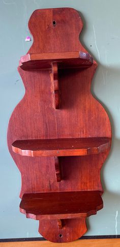 a wooden shelf sitting on top of a hard wood floor next to a white wall