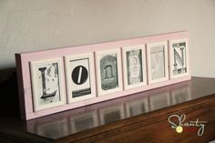 a wooden box with four framed photos on it sitting on top of a table next to a lamp