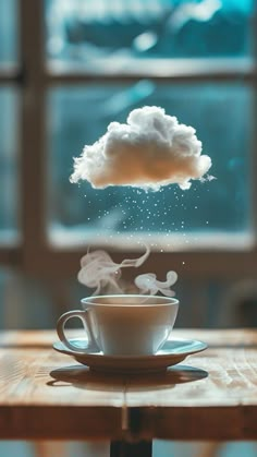 a coffee cup sitting on top of a wooden table next to a cloud shaped object