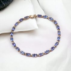 Indulge in the allure of timeless glamour with our Handmade Tanzanite Stone Tennis Cushion Cut Bracelet, a masterpiece of elegance meticulously crafted in 925 sterling silver.  Our artisans, with their unwavering commitment to excellence, have meticulously designed this bracelet to be a true work of art. The 925 sterling silver setting, enhanced by gold rhodium plating , reflects a perfect blend of classic and contemporary design. Cushion Tanzanite, with its captivating violet-blue shades, is renowned for its unique and mesmerizing color. Tanzanite is believed to have spiritual properties, promoting calmness and enhancing communication. Tanzanite is exclusively found in Tanzania, making it a rare and precious gem. The geographical uniqueness imparts a distinct character to each stone, ensu Tanzanite Bracelet, Timeless Glamour, Bracelet For Her, Art Deco Bracelet, Tanzanite Stone, Blue Tanzanite, Precious Gems, Bracelet For Women, Wedding Bracelet