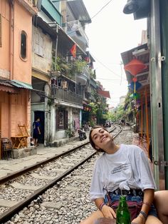 a woman is sitting on the train tracks