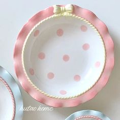 three plates with pink and blue polka dots on them, one has a bow at the top