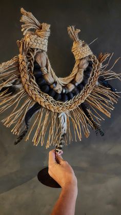 a hand holding a piece of art made out of rope