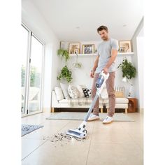 a man vacuuming the floor in his living room