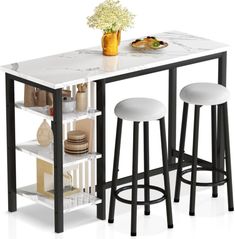 a kitchen table with two stools next to it and a plate on the counter